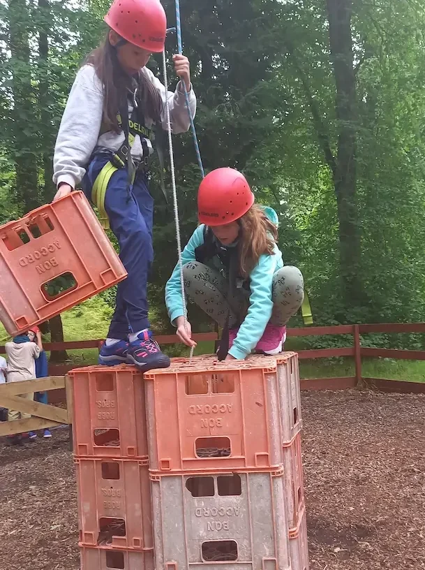 cnag-homepage Girls climbing up milk crates as a challenge